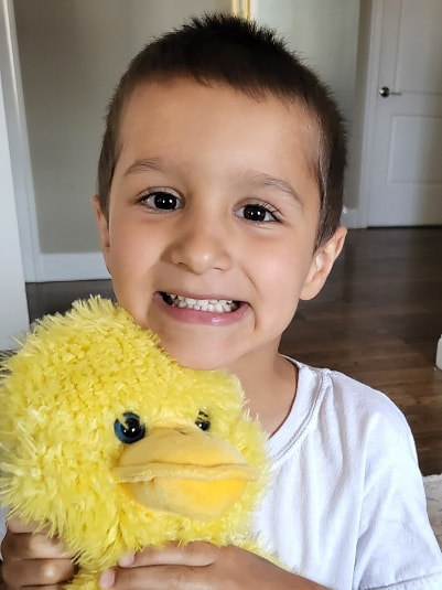 Peter holding a stuffed animal after his surgery